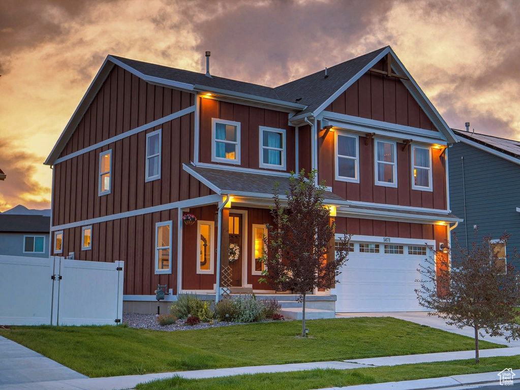 View of front facade featuring board and batten siding, an attached garage, roof with shingles, concrete driveway, and a gate