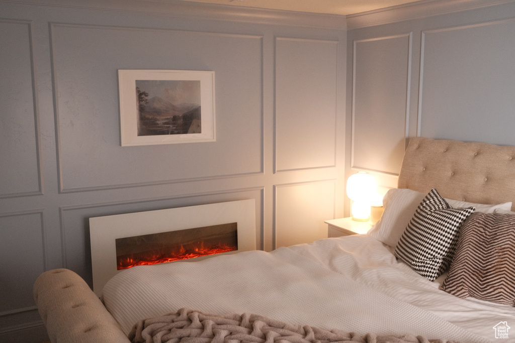 Bedroom with a decorative wall and a lit fireplace