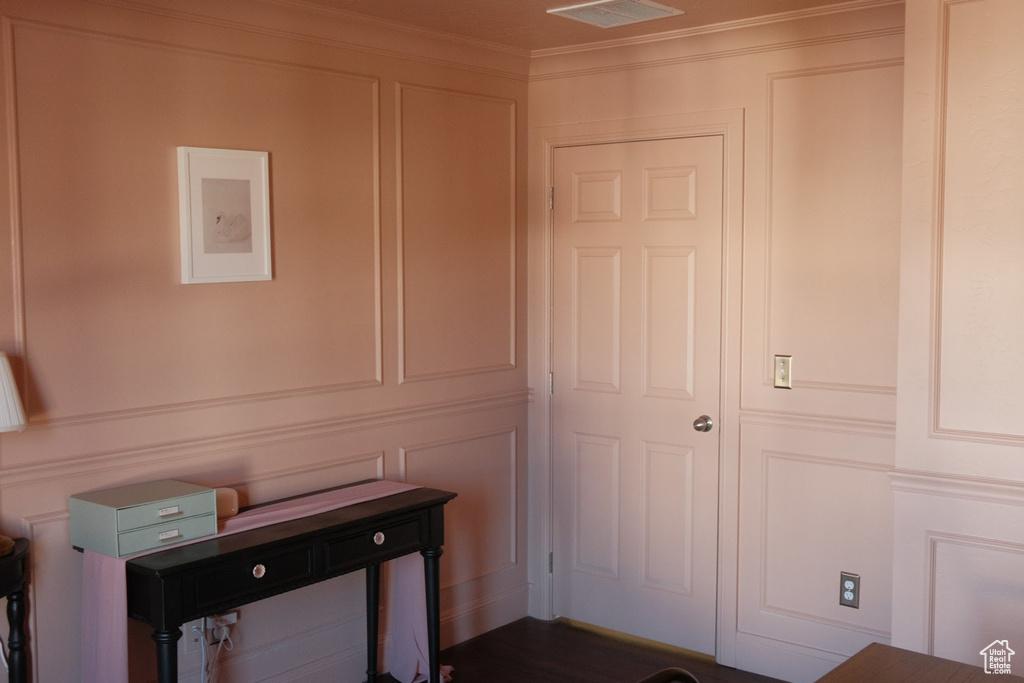 Unfurnished office featuring a decorative wall and ornamental molding