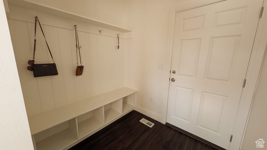 Mudroom featuring dark wood-style flooring and baseboards