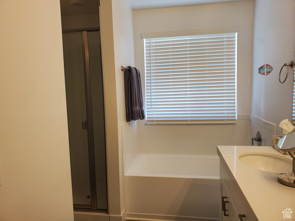 Full bathroom featuring a stall shower, vanity, and a bath