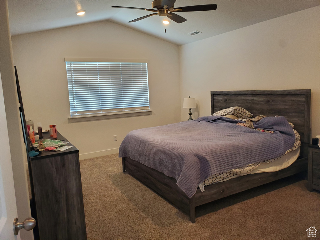 Bedroom with carpet, vaulted ceiling, and a ceiling fan