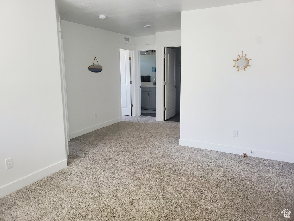 Unfurnished room with carpet and a smoke detector
