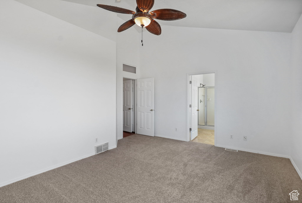 Unfurnished bedroom featuring light colored carpet, high vaulted ceiling, and connected bathroom