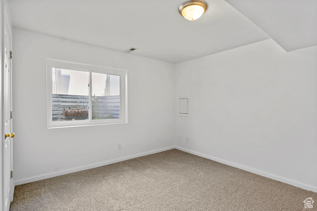Carpeted empty room with baseboards