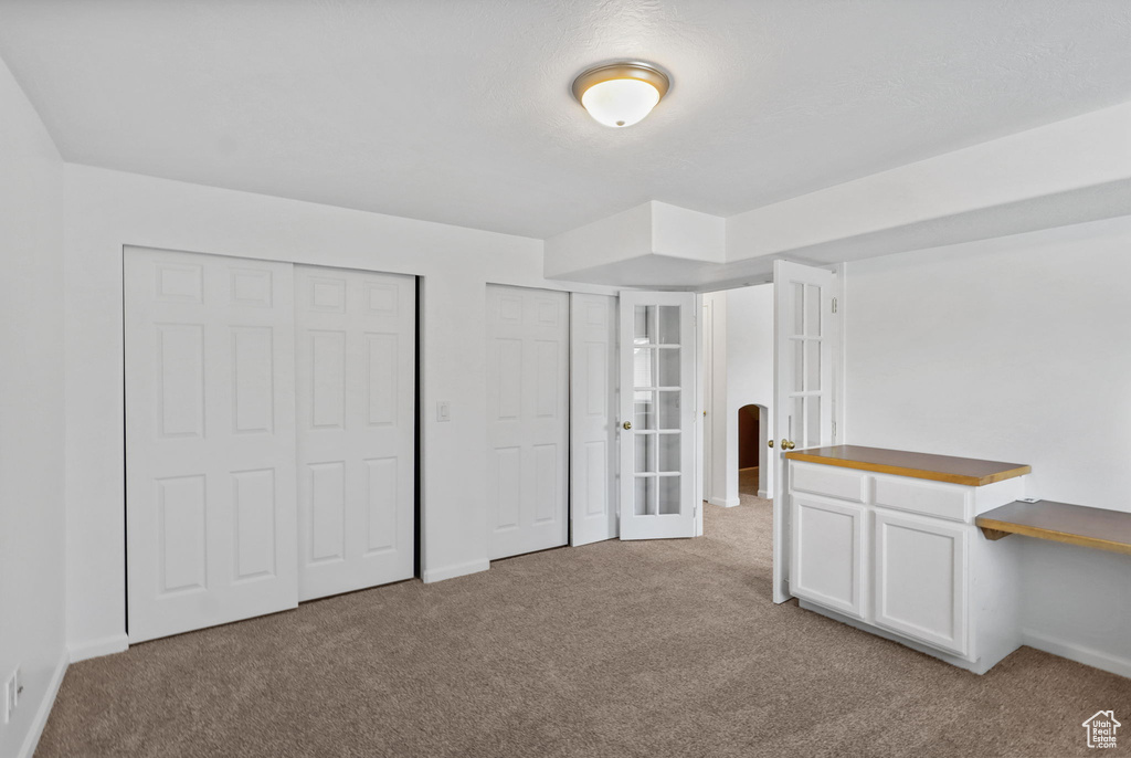 Unfurnished bedroom featuring carpet and french doors
