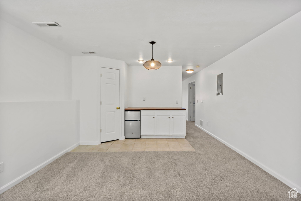 Spare room featuring light carpet and light tile patterned floors