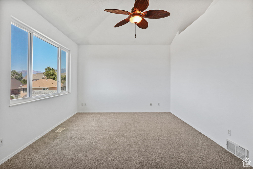 Unfurnished room featuring carpet flooring, a ceiling fan, and lofted ceiling