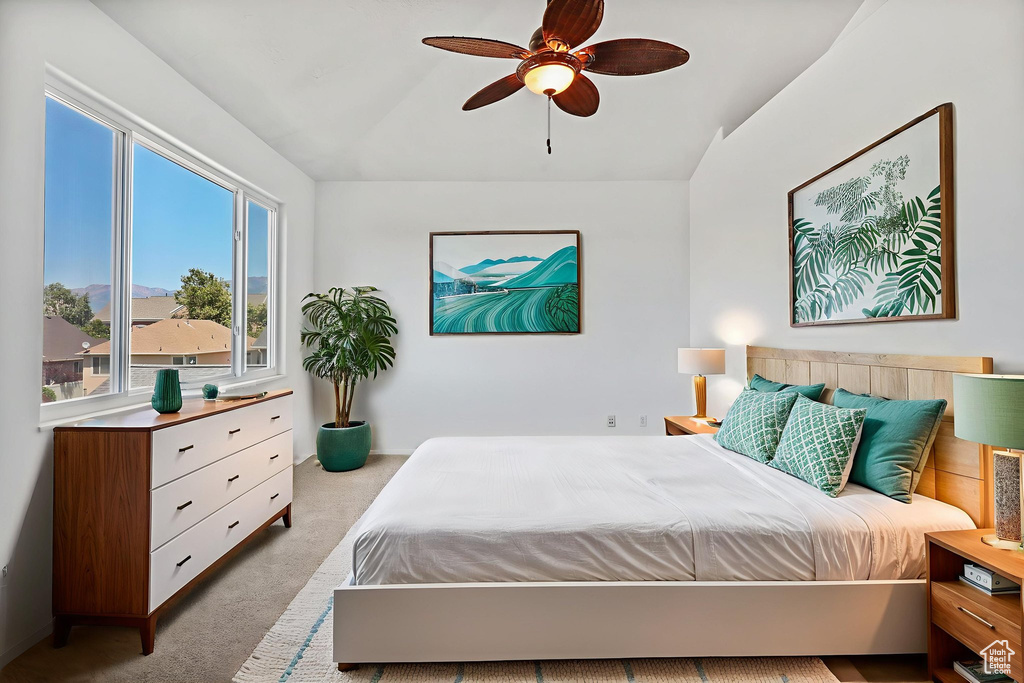 Carpeted bedroom featuring lofted ceiling and ceiling fan