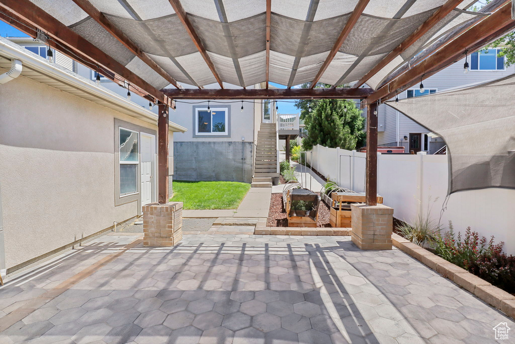 View of patio with stairway and a pergola