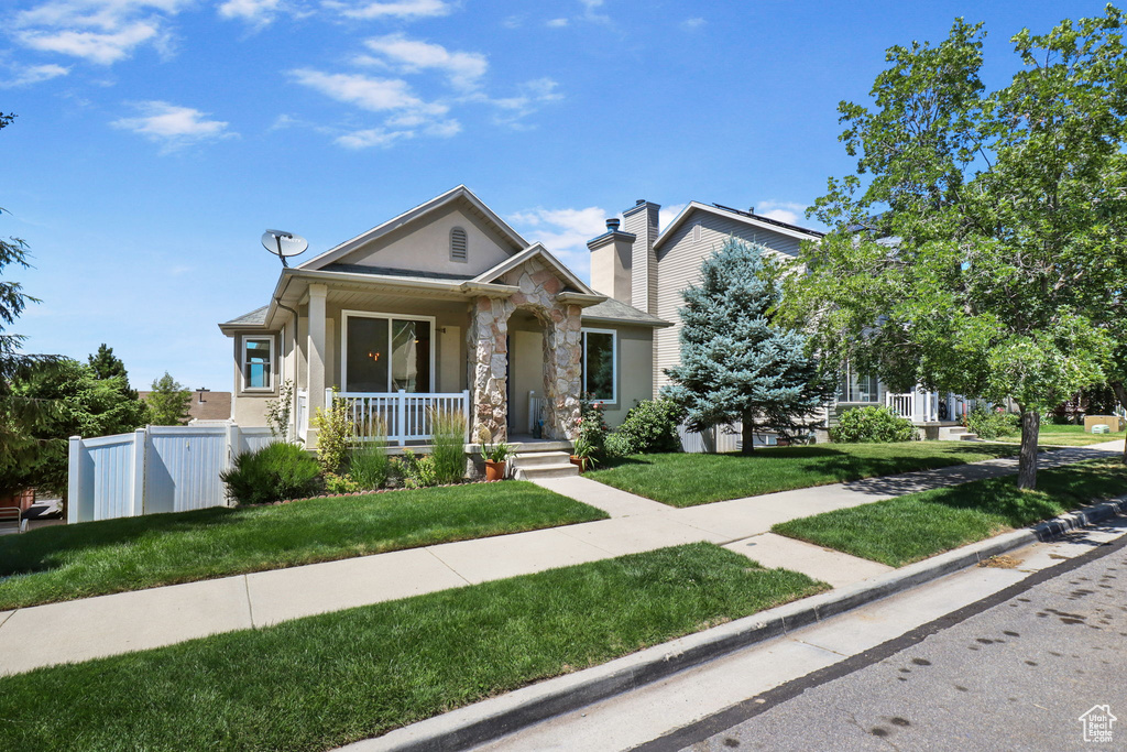 View of front facade featuring stone siding, a porch, and stucco siding