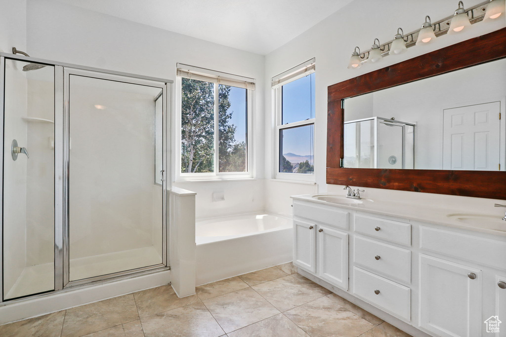 Bathroom featuring a shower stall, a bath, double vanity, and tile patterned floors