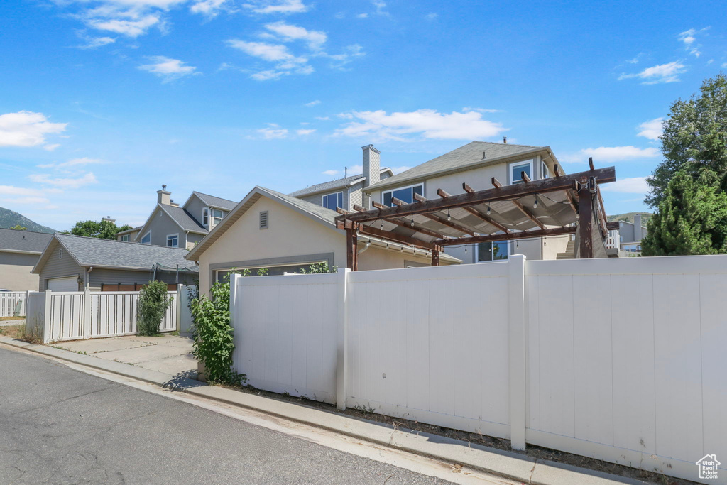 View of front of house with a pergola, stucco siding, and a garage