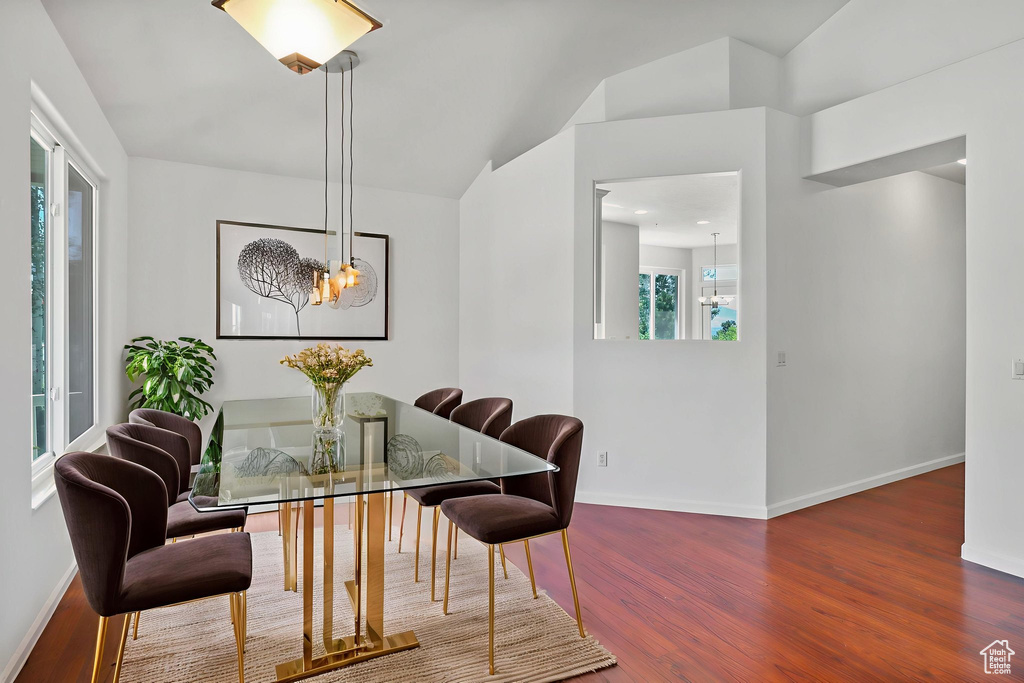 Dining room featuring a chandelier, wood finished floors, and vaulted ceiling