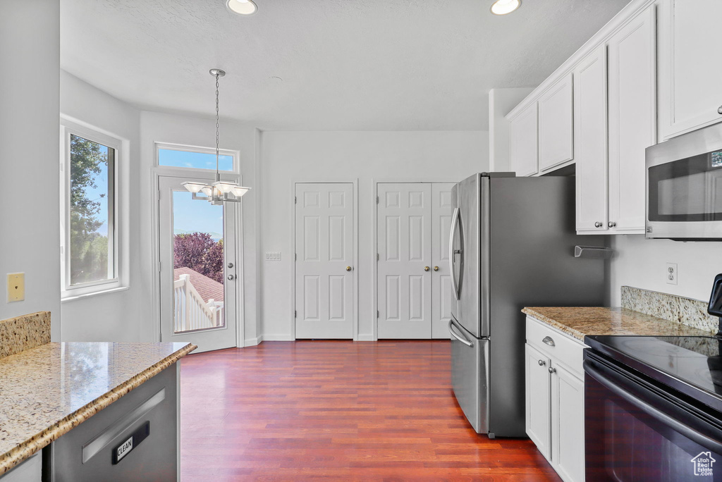 Kitchen with appliances with stainless steel finishes, a chandelier, dark wood-style floors, white cabinets, and recessed lighting