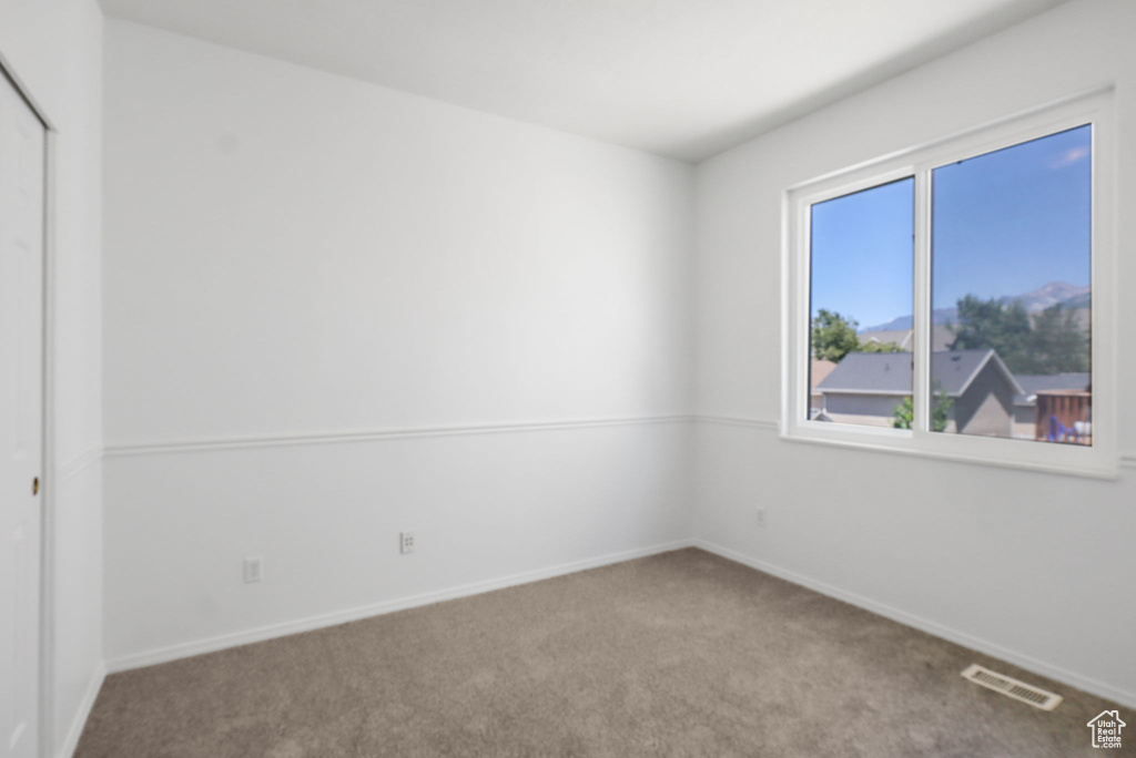 Carpeted empty room with baseboards