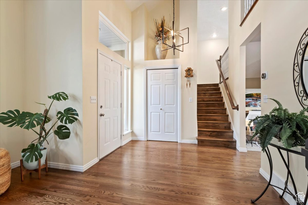Foyer featuring stairs, wood finished floors, and a high ceiling