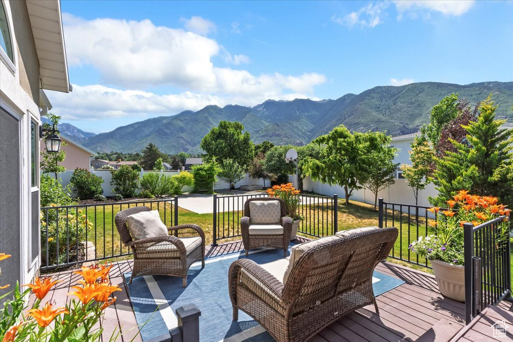 Wooden deck with a mountain view, outdoor lounge area, and a yard