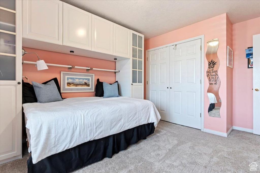 Carpeted bedroom featuring a closet and baseboards