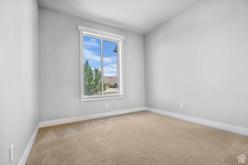 Unfurnished room featuring carpet floors and baseboards