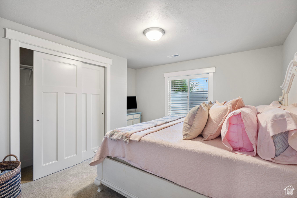 Bedroom with carpet and a closet
