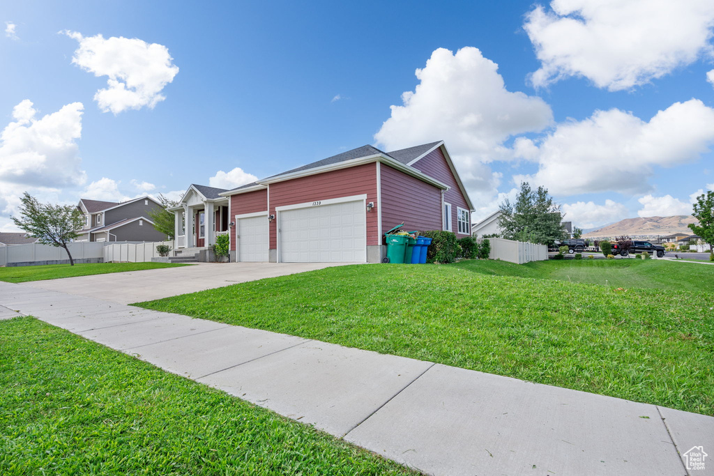 Ranch-style home featuring an attached garage, concrete driveway, and a mountain view