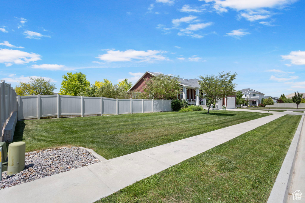 Fenced yard featuring a garage and driveway