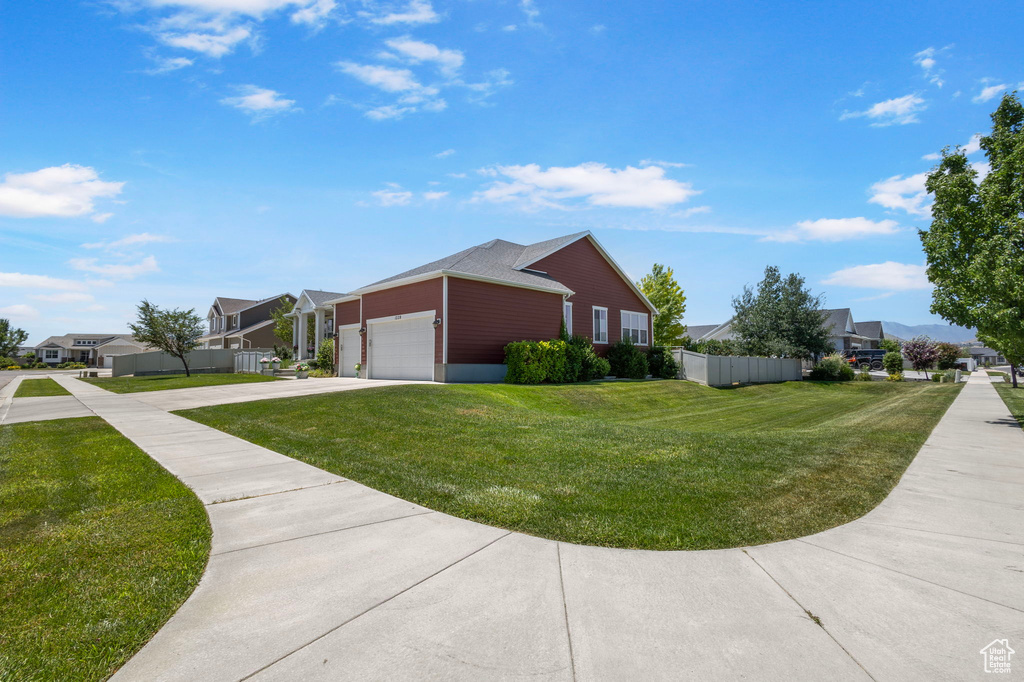 View of side of property featuring a residential view, a garage, and driveway