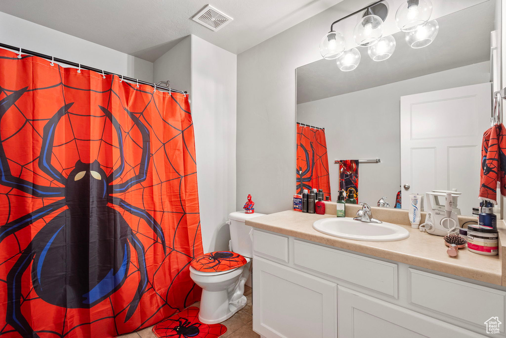 Full bath with tile patterned floors, vanity, and curtained shower