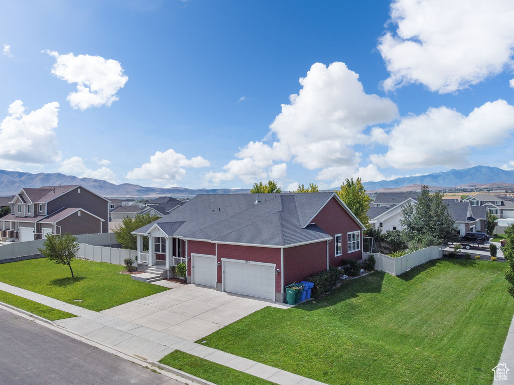 View of front of home with a residential view, a mountain view, a garage, driveway, and a shingled roof