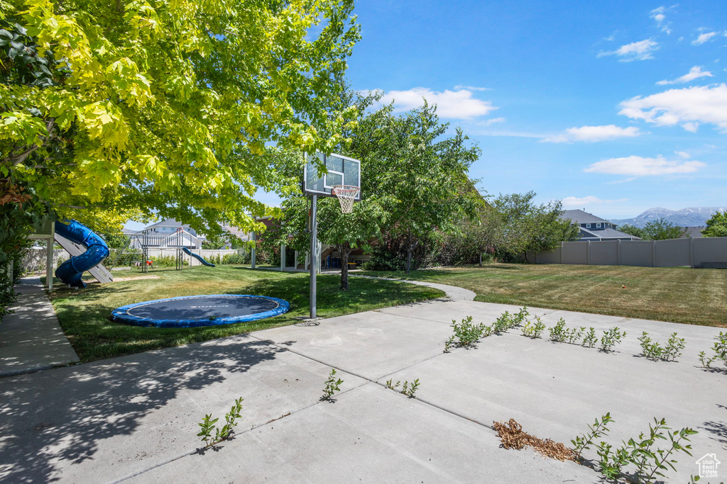 View of patio with a trampoline and a playground
