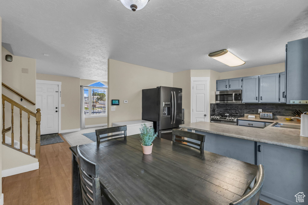 Dining room featuring wood finished floors, a textured ceiling, and stairway