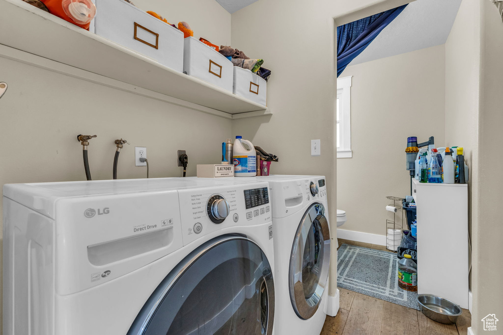 Washroom featuring washer and dryer and wood finished floors