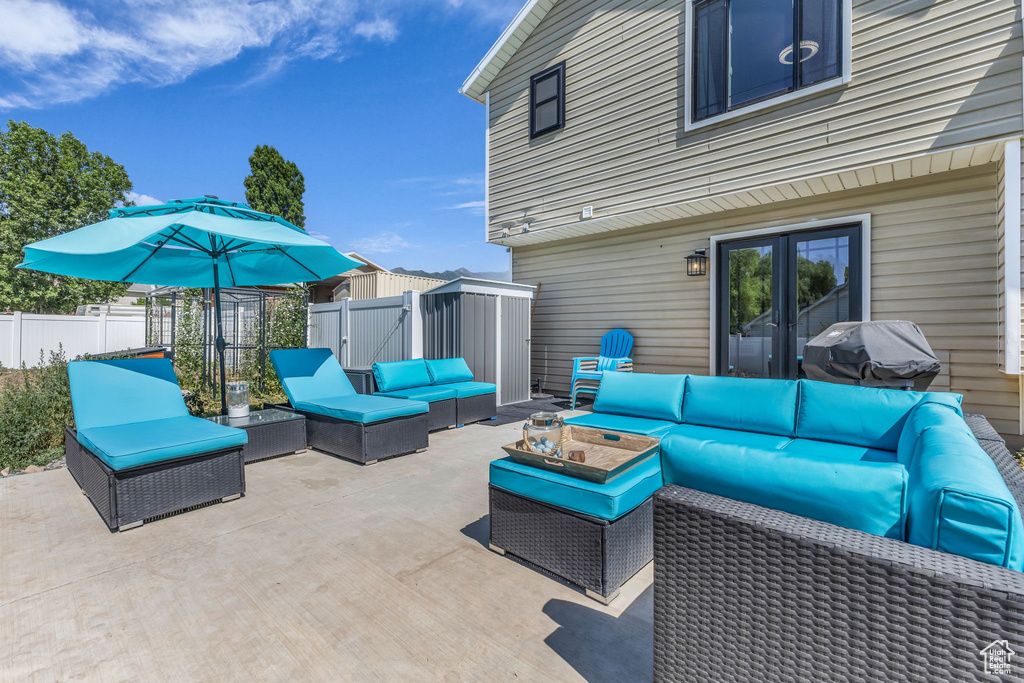View of patio featuring outdoor lounge area, a gate, grilling area, and french doors