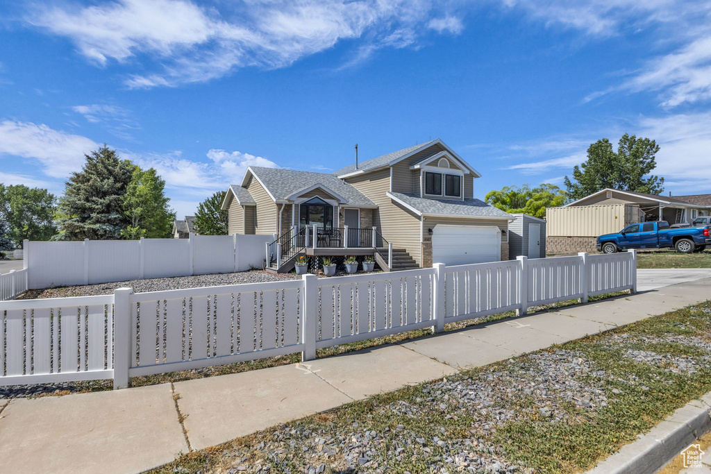 View of front facade featuring an attached garage and a fenced front yard