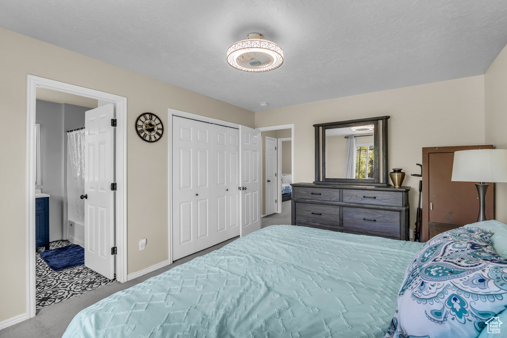 Carpeted bedroom featuring baseboards and connected bathroom
