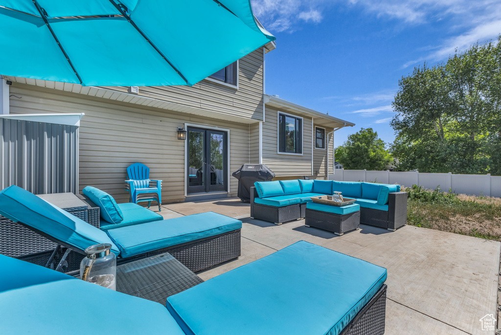 Fenced backyard featuring french doors, an outdoor living space, a patio area, and grilling area