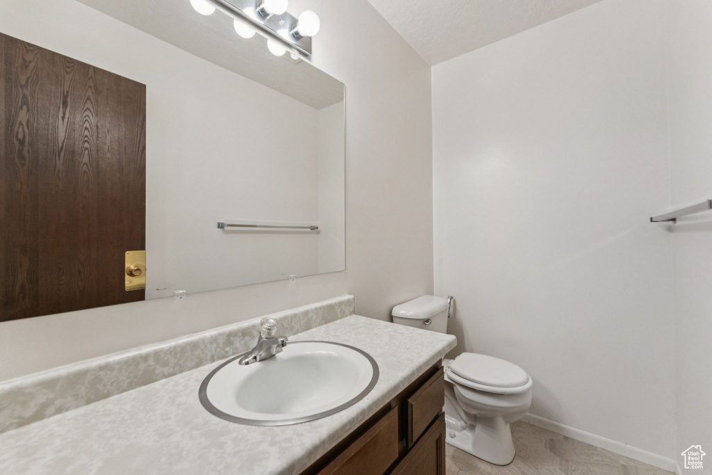 Half bathroom featuring vanity and toilet