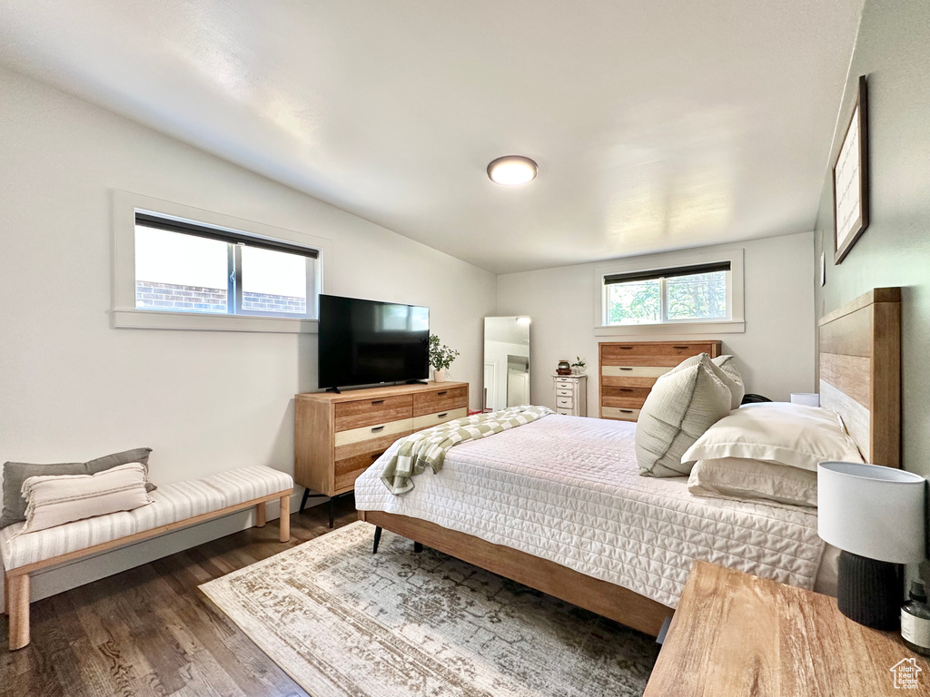Bedroom with wood finished floors and lofted ceiling