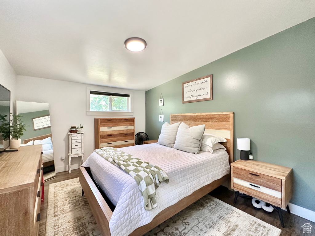 Bedroom with wood finished floors and baseboards