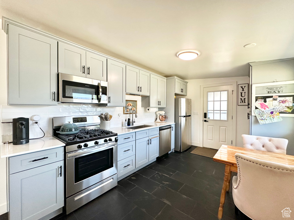 Kitchen with appliances with stainless steel finishes, light countertops, and tasteful backsplash