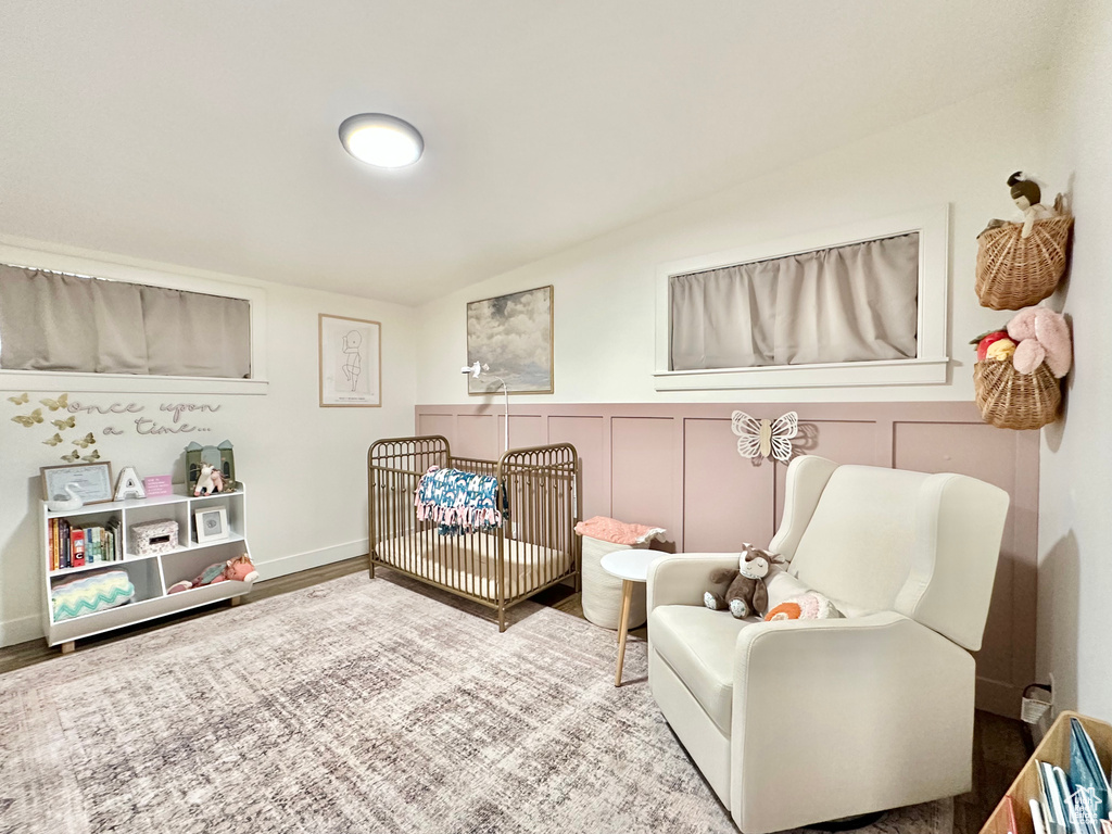 Bedroom with a crib and wood finished floors