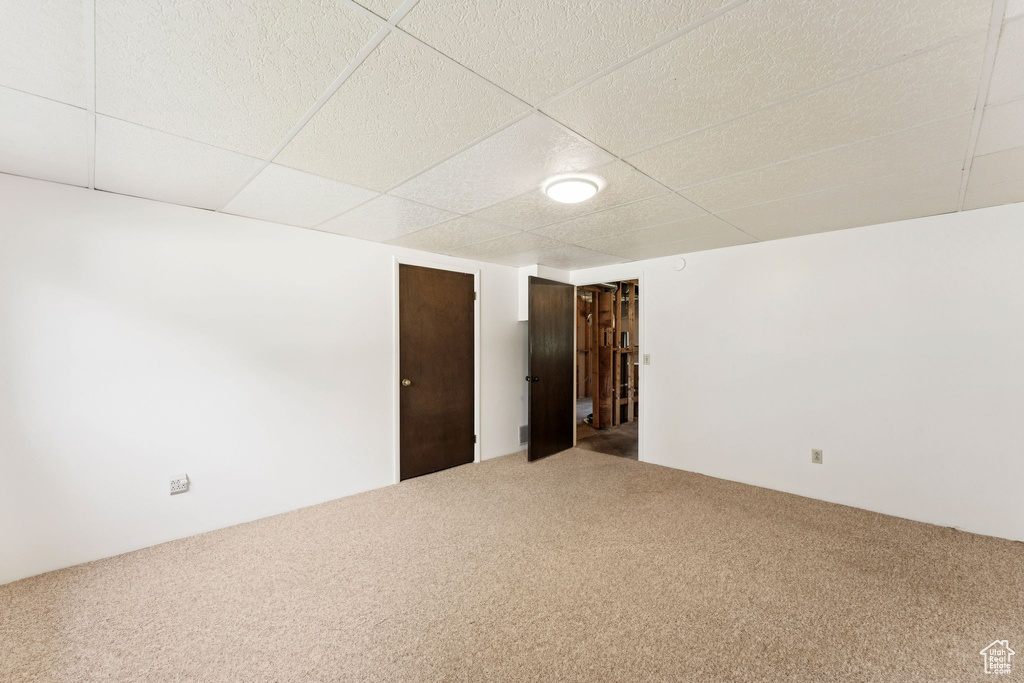 Spare room featuring carpet flooring and a paneled ceiling