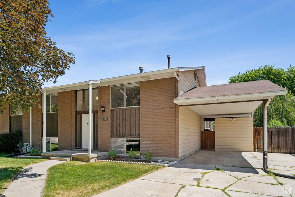 View of front of house featuring driveway and brick siding