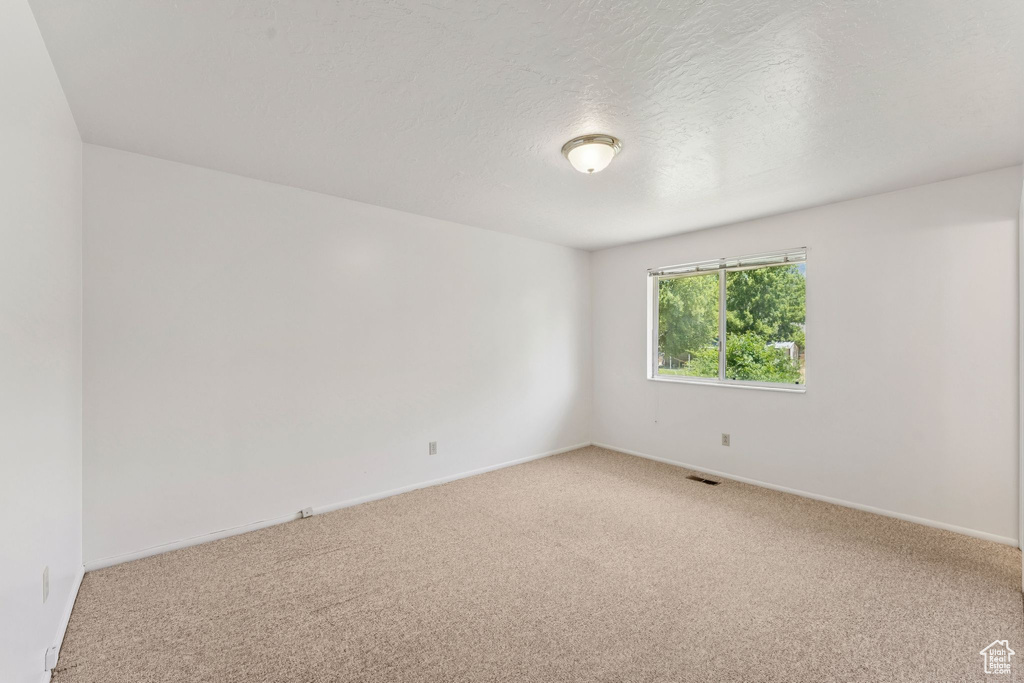 Unfurnished room featuring light colored carpet and baseboards
