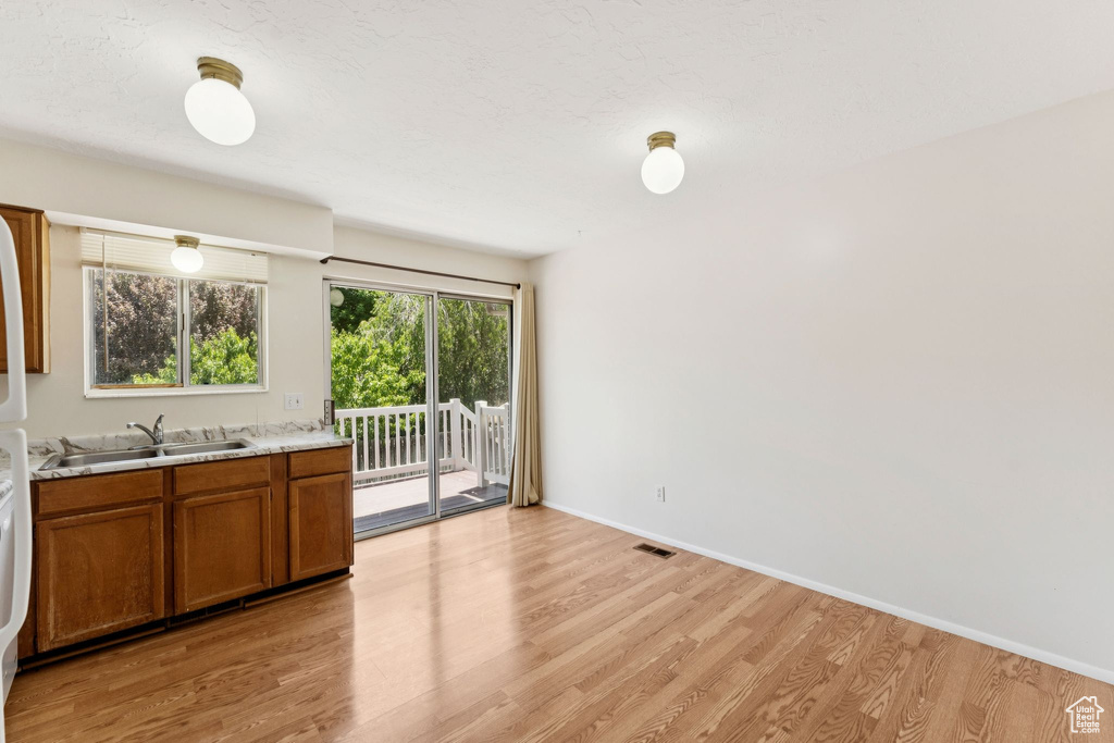 Kitchen with brown cabinetry, light wood-style flooring, and light countertops