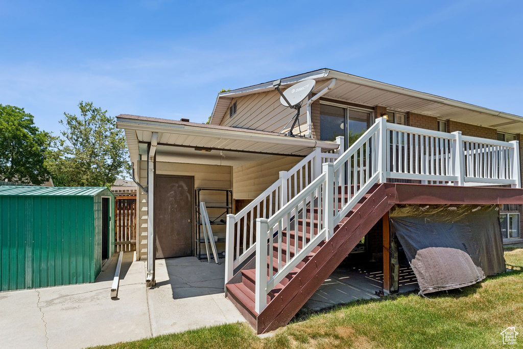Back of house featuring a patio area, a shed, and stairs
