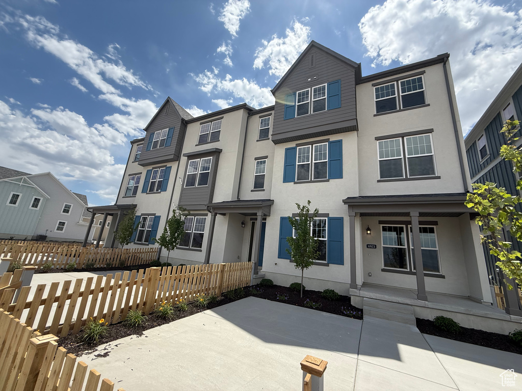 View of property with stucco siding, a residential view, and a porch