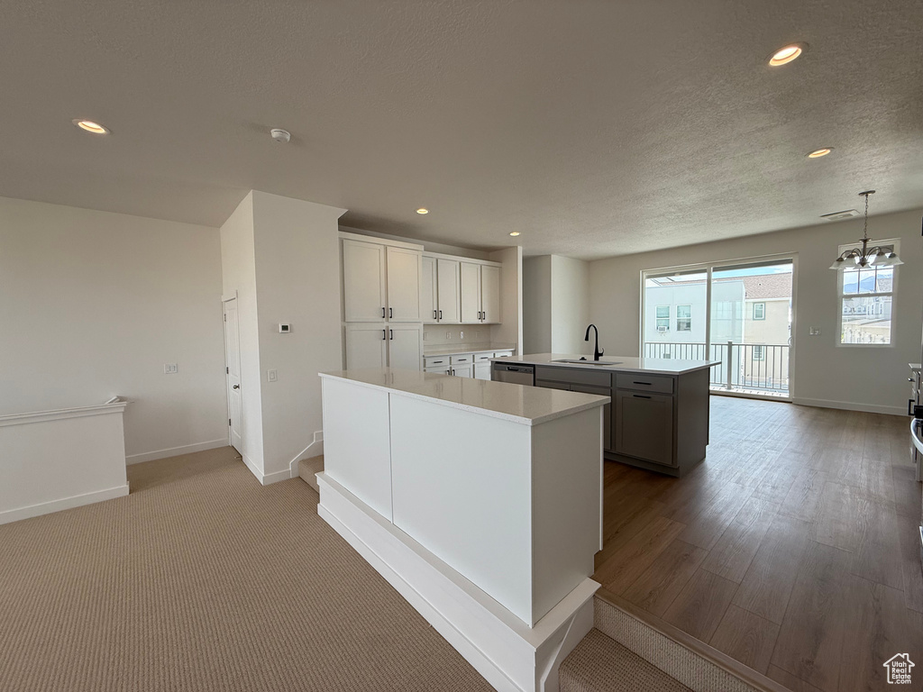 Kitchen featuring an island with sink, recessed lighting, light countertops, dishwasher, and pendant lighting