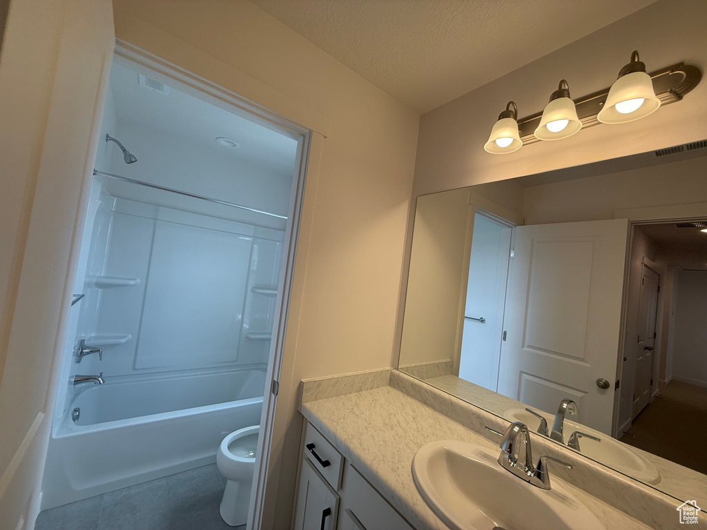 Bathroom with vanity, shower / tub combination, tile patterned flooring, and a textured ceiling